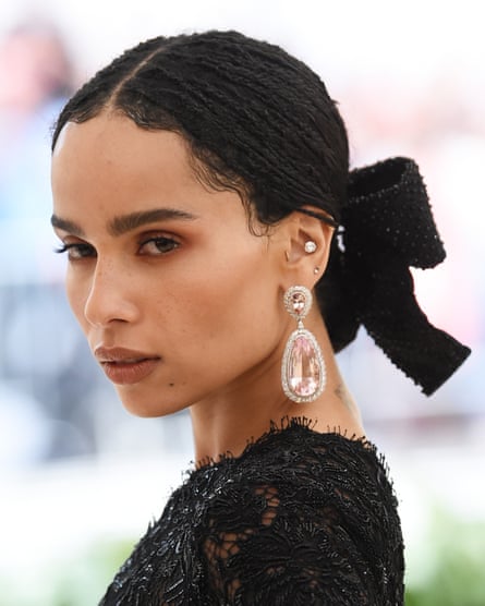 A fashion-forward woman with multiple gold ear piercings styled in a curated ear stack.