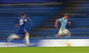 Kevin De Bruyne of Manchester City runs with the ball under pressure from Billy Gilmour of Chelsea.