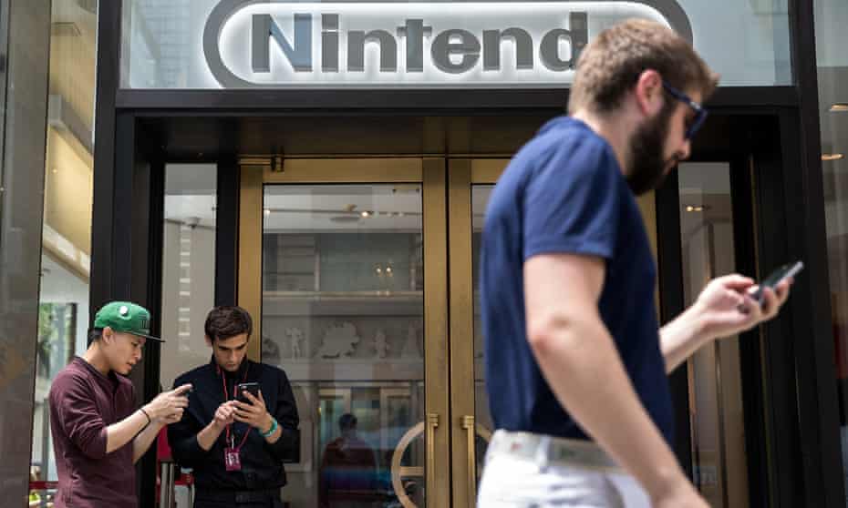 Two men play Pokémon Go outside Nintendo’s flagship store in New York.