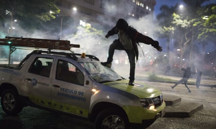 A demonstrator breaks the windshield of a truck in Rio de Janeiro.