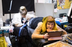 A woman watches a film on an iPad as she gets a tattoo International Tattoo Festival