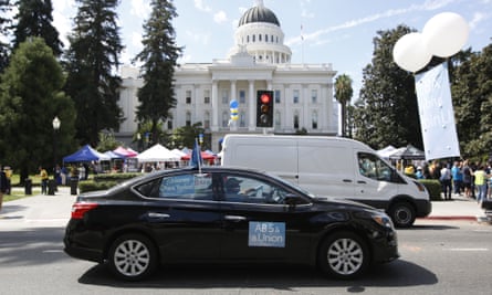 A rideshare driver supporting the AB5 bill drives past the California statehouse in Sacramento.