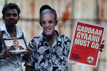 A demonstrator holds a sign saying: ‘Resign Gyanesh Kumar’