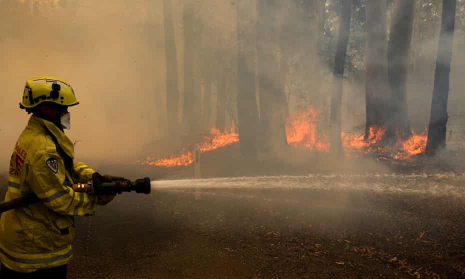 A Gloucester fire crew member fights flames at Koorainghat, near Taree
