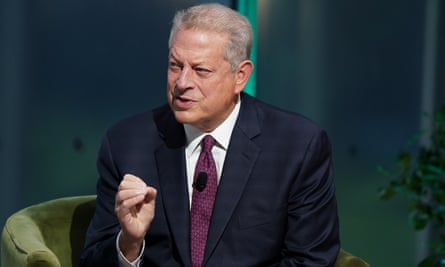 Al Gore, leaning forward while seated, gestures with his right hand.