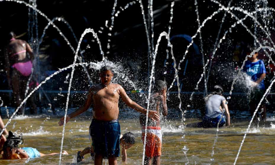 A boy cools off in a fountain on a bank of the river Manzanares in Madrid on June 18, 2017, as temperatures rose high across Spain. Spain goes through a heatwave with temperatures soaring above 40 degrees Celsius (104 degrees Fahrenheit) in some places including the Spanish capital.