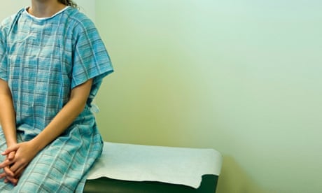 Young female patient waiting on examination table.