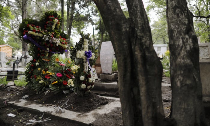 Crosses of fresh flowers adorn a new grave at Xilotepec Cemetery amid the new coronavirus pandemic, in Xochimilco, Mexico City, 27 July 2020.