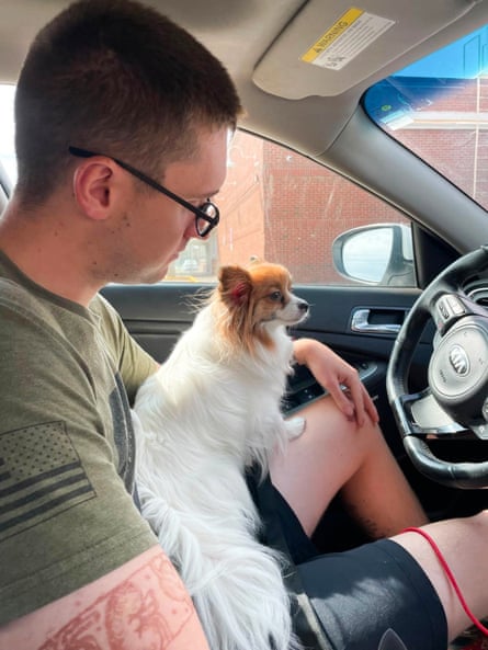 a man sits with his dog in a car
