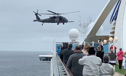 Passengers on board the Grand Princess watch while a US military helicopter delivers coronavirus tests.