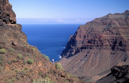 A walker on the mountain path to Playa de Guigui, Gran Canaria.