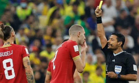 Iranian referee Alireza Faghani (right) shows a yellow card to Serbia's defender Strahinja Pavlovic for a foul on Brazil's Neymar.