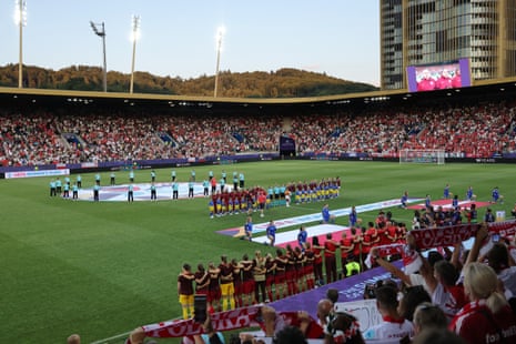 Denmark and Poland players line up during the national anthems before the match.