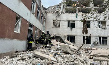 Firefighters stand in the rubble of an apartment building hit by a missile