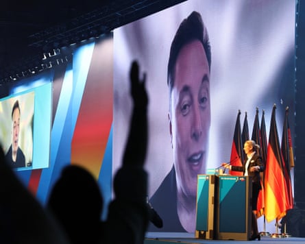 AfD co-leader Alice Weidel addresses a cheering crowd in front of a screen image of Elon Musk