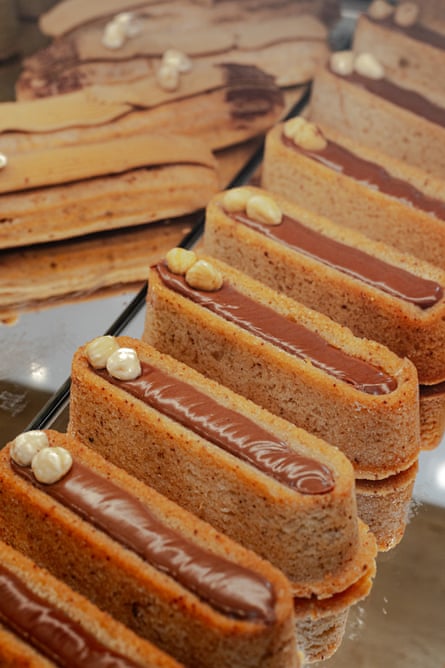 صف من الخبز الشبيه بالتمويل بالشيكولاتة على رف زجاجي