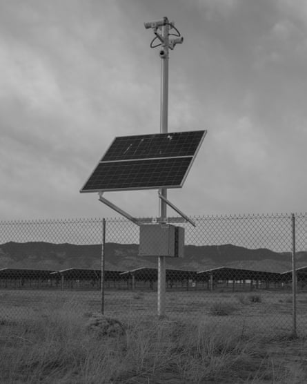 An erect solar panel behind a fence