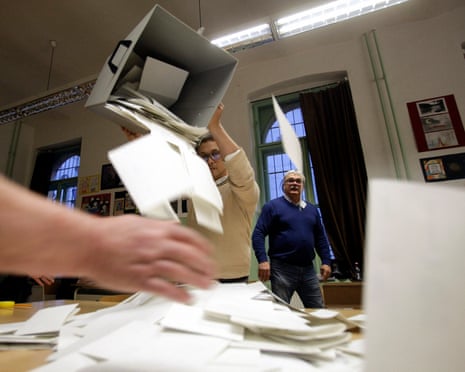 An election helper empties a ballot box for the counting of votes as polls closed in the general election at a polling station in Budapest.