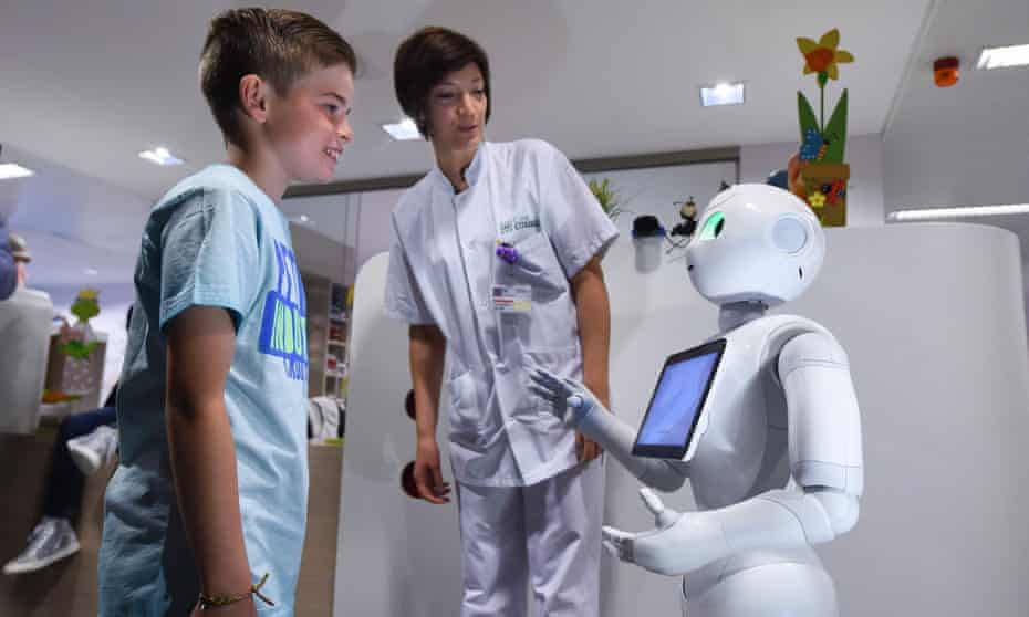 A young boy talks with the robot Pepper next to a nurse during a press conference at the CHR Citadel hospital centers of Liege. 