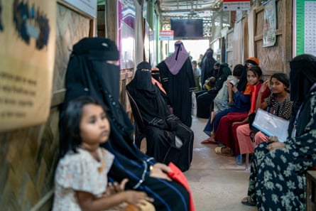 Women and children line a corridor.