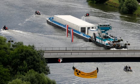 A ship carries nuclear waste containers along the Neckar in Bad Wimpfen, Germany, as environmentalists hang under a bridge to try to block it. 