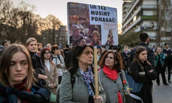 Kobieta trzyma tabliczkę z napisem „Uchodźcy są mile widziani”.