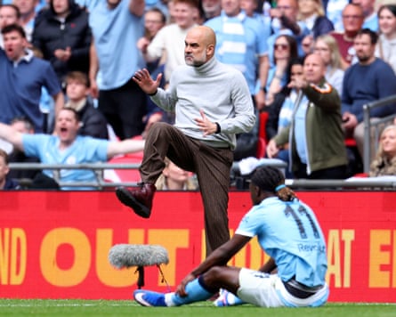Pep Guardiola mimes a kick on the touchline