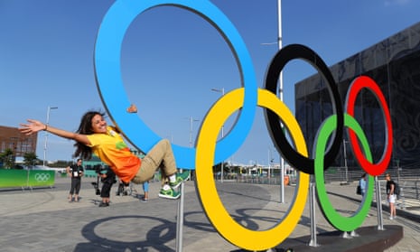 A Games volunteer and fan of the Olympic Rings in the Barra Olympic park.