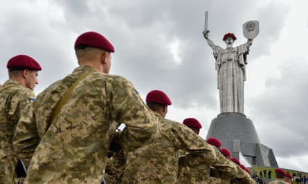 Soldiers march by the 102-metre-high Motherland monument in Ukraine.
