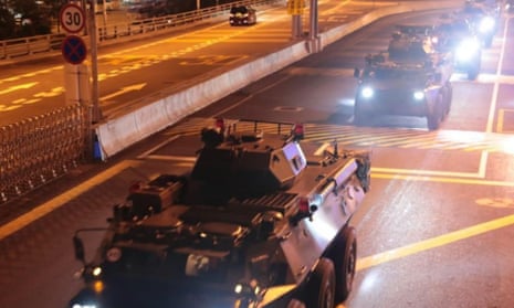 Chinese military vehicles move across the border into Hong Kong on Thursday.