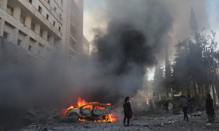 A car burns after an airstrike next to a hospital in Idlib, Syria, 2 December 2024.