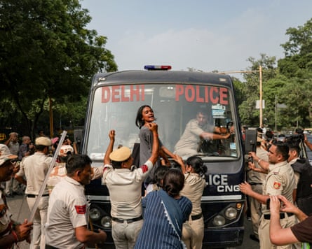 A protestor blocks a bus.