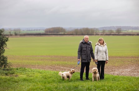 Andy and Dorne Johnson and their two dogs on farmland near their home in Lincolnshire, UK, which is set to be used for a solar farm