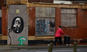 A woman walks past graffiti in Gipsyville