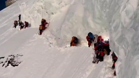 Mountaineers appear to walk past injured porter to set K2 record – video