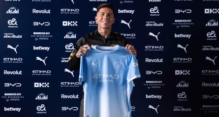 Enzo Fernández holding a Manchester City shirt