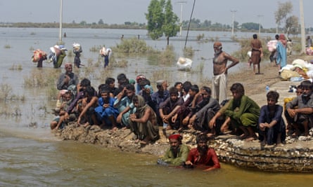 Pakistani victims of heavy flooding from monsoon rains wait to receive relief aid in the Qambar Shahdadkot district of Sindh province, in September 2022.