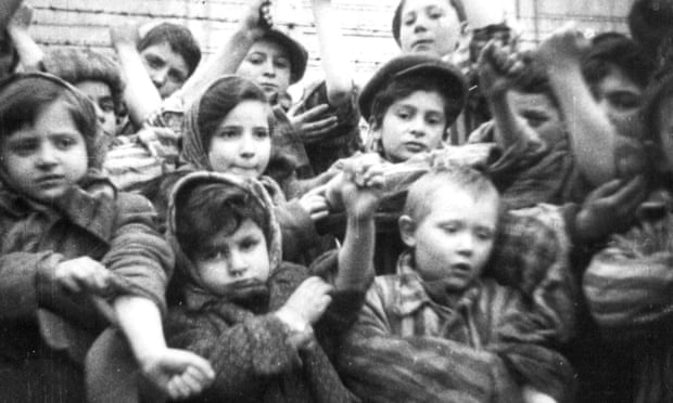 Children show their tattooed identification numbers during the liberation of Auschwitz