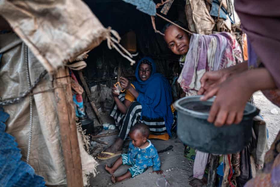 A family sits in a makeshift kitchen.