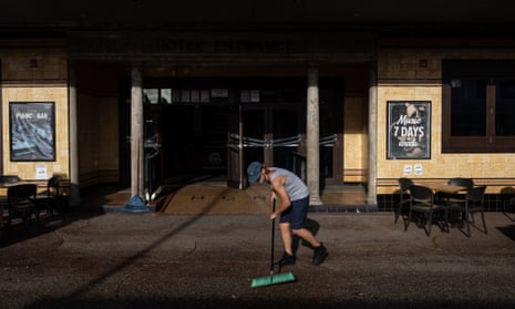 A worker cleans the street in front of the Great Northern Pub in Byron Bay after flooding hit the NSW northern rivers.