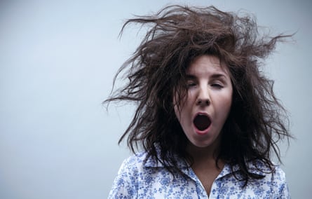 A woman yawning with her hair totally dishevelled
