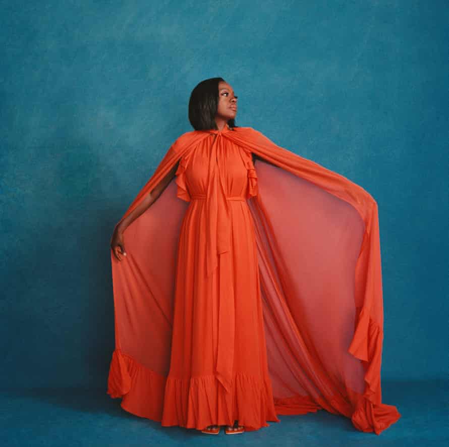 Viola Davis wearing a long orange gown with a cape