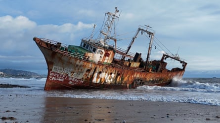 A rusty trawler aground on a beach