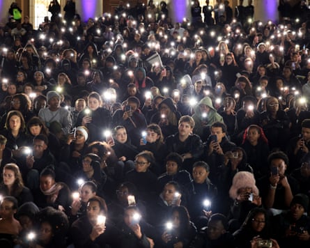 People hold their mobile phones with the torch lights on during a night-time vigil