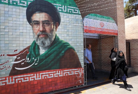 Iranians walk past a picture of Iranian supreme leader Ayatollah Mojtaba Khamenei in a street in Tehran, Iran.