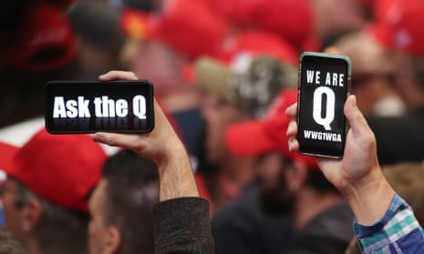 Trump supporters hold up their phones with QAnon messages at a campaign rally at the Las Vegas convention center, 21 February 2020.