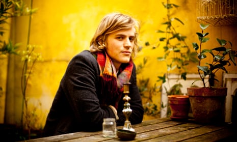 Musician and actor Johnny Flynn sitting at a wooden bench in 2012