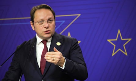 Olivér Várhelyi gesturing as he speaks at a podium