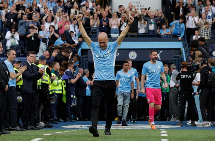 Pep Guardiola walks onto the pitch for the trophy presentation ceremony.