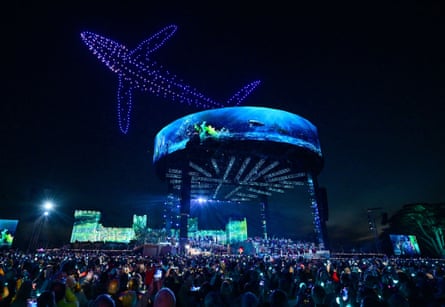 Crowds watch illuminated drones creating a light display above Windsor Castle during the coronation concert, 7 May